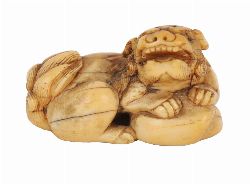 JAPANESE IVORY NETSUKE OF A RECLINING SHISHI