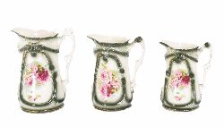 SET OF THREE GRADUATED CERAMIC JUGS WITH PAINTED FLOWERS