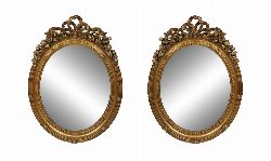 PAIR OF OVAL GILTWOOD MIRRORS WITH RIBBON AND FLORAL CRESTINGS