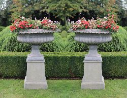 PAIR OF LARGE COMPOSITION STONE TAZZA-FORM GARDEN URNS ON PEDESTALS