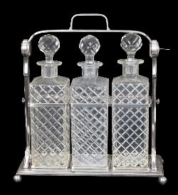 LATE VICTORIAN SILVER-PLATED AND CUT CRYSTAL THREE BOTTLE TANTALUS