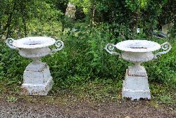 PAIR 19TH-CENTURY LARGE WHITE-PAINTED CAST IRON URNS ON PLINTHS