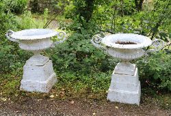 PAIR 19TH-CENTURY LARGE WHITE-PAINTED CAST IRON URNS ON PLINTHS