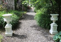 PAIR OF CLASSICAL CAST IRON GARDEN URNS EACH ON PLINTH
