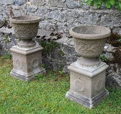 PAIR OF COMPOSITE STONE URNS ON SQUARE PLINTHS