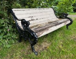 19TH-CENTURY CAST IRON GARDEN SEAT WITH SCROLL ENDS AND LION MASK DECORATION