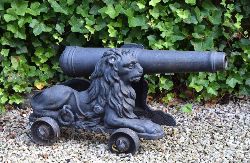 EARLY 19TH-CENTURY HEAVY CAST IRON CANNON, SUPPORTED BY RECUMBENT LION FOUR-WHEEL CARRIAGE 